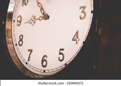 Close up face of wooden antique vintage grandfather clock. Close up clock face for background concept.