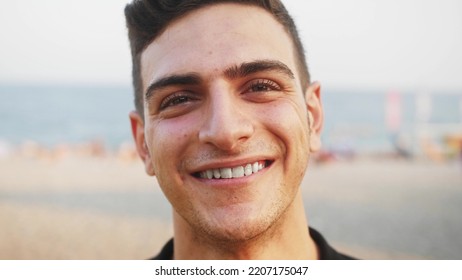 Close Up Face Of Young Arab Man. Handsome Arabian Man Standing Outdoors Alone Smiling Looking At Camera.