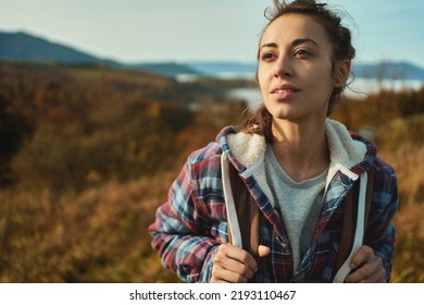 Close Up Face Young Confident Woman Hiker Standing On The Slope Of Mountain Ridge Against Mountains, Looking Away, Enjoying The Epic View