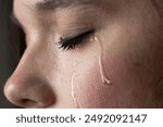 close up of the face of a young woman with tears on her cheek