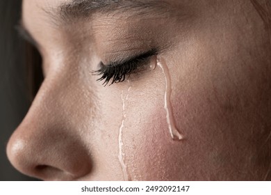 close up of the face of a young woman with tears on her cheek - Powered by Shutterstock