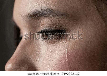 close up of the face of a young woman with tears on her cheek