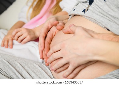 Close up of family hands on pregnant tummy - Shutterstock ID 1683435337