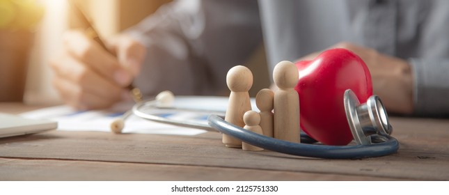 Close Up Family Wooden Doll And Rad Hard And Medical Stethoscope For Insurance Planning Protection And Safety Family Health Concept.