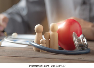 Close Up Family Wooden Doll And Rad Hard And Medical Stethoscope For Insurance Planning Protection And Safety Family Health Concept.