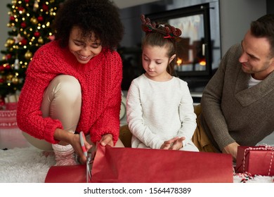 Close Up Of Family Wrapping Christmas Gifts 