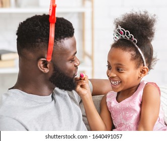 Close Up Of Fancy Black Father And Daughter Wearing Make Up, Little Girl Putting Lipstick On Her Dad's Lips