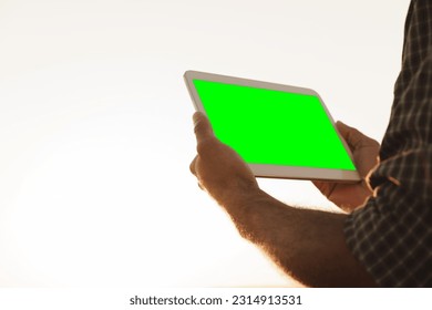 Close up of farmer's hands holding tablet with green screen - Powered by Shutterstock