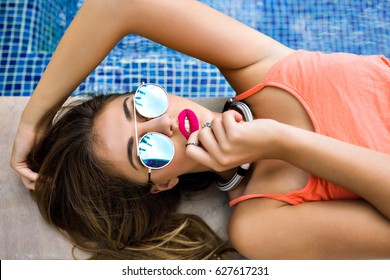 Close Up Fashion Portrait Of Elegant Pretty Blonde Woman, Bright Full Sexy Lips, Mirrored Sunglasses, Lay And Relaxed Near Pool, Luxury Vacation Style.