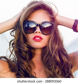 Close Up Fashion  Summer  Portrait Of Stylish  Sexy  Woman With Perfect  Tanned Fit Body   Wearing Trendy Sunglasses Drinking Cocktail And  Enjoying  Pool Party On Luxury Villa. 