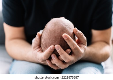 Close Up Of A Father Holding The Head Of His Newborn Baby In His Hands