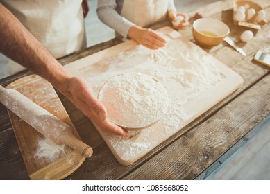 Close up of father and son cooking together. Focus on adult arms holding bowl with flour - Shutterstock ID 1085668052