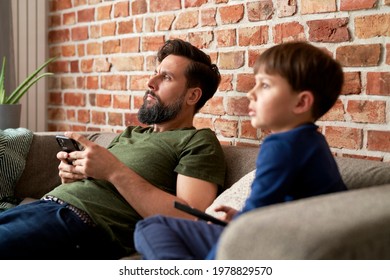 Close up of father and son watches TV together at home