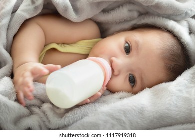 Close up of  feeding  baby with milk infant hold bottle - Powered by Shutterstock