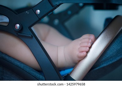 Close Up Feet Of Baby Who Is Sleep In Stroller Or Car Seat.