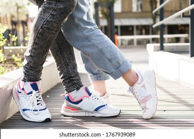 Close up of feet. Couple wearing sneakers in embrace.