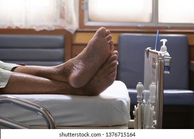 Close Up Feet Of Elderly Over 80 S Asian Man Patient Lie Down On Bed After Chemotherapy Of Liver Cancer In Hospital Ward Room, Senior Man Lie Down On Bed In Hospital Waiting The Doctor Examining.