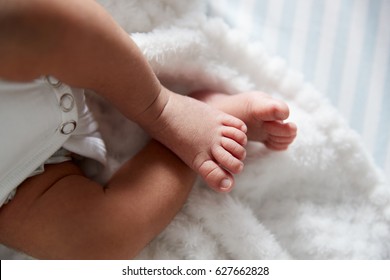 Close Up Of Feet Of Newborn Baby In Nursery Cot
