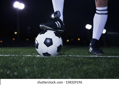 Close up of feet on top of soccer ball on the line