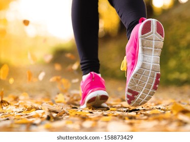 Close Up Of Feet Of A Runner Running In Autumn Leaves Training Exercise