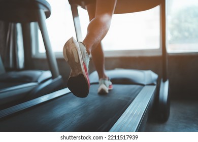 Close up of feet, sportman runner running on treadmill in fitness club. Cardio workout. Healthy lifestyle, guy training in gym. Sport running concept