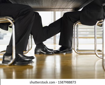 Close Up Of Businesspeople�s Feet Touching Under Table