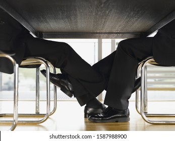 Close Up Of Businesspeople�s Feet Touching Under Table