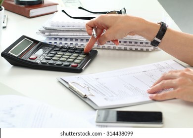 Close up of female accountant or banker making calculations. Savings, finances and economy concept - Shutterstock ID 314438099