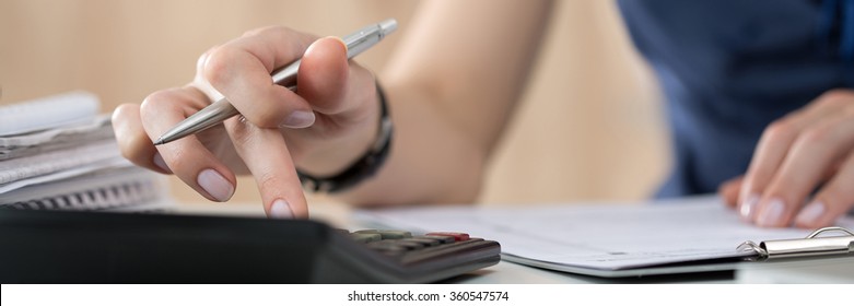 Close up of female accountant or banker making calculations. Savings, finances and economy concept. Letter box format
