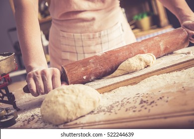 Close up of female baker hands kneading dough and making bread with a rolling pin. Retro look. - Powered by Shutterstock