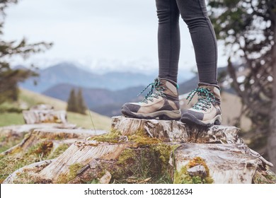 Close Up Of Female Classic Leather Hiking Boots Wearing By Woman Standing On Stump In Mountains - Travel And Outdoor Activities Concept