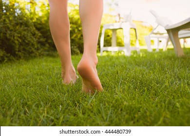 Close Up Female Crossed Legs Walking On The Grass In A Park.