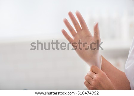 Close up of female doctor hand wearing sterile glove