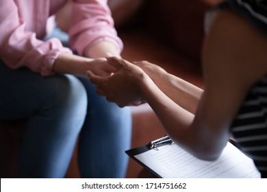 Close up of female doctor hold woman patient hands help on personal therapy session, psychologist or counselor show understanding and care, support depressed suffering client on treatment - Shutterstock ID 1714751662