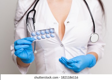 Close up of female doctor holding pill for men health - Shutterstock ID 1821186116