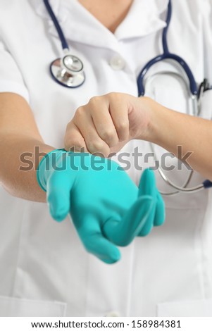 Close up of a female doctor putting latex gloves isolated on a white background