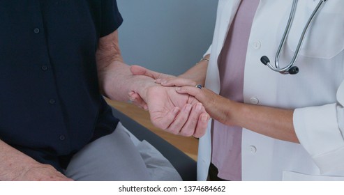 Close Up Of Female Doctor Taking Senior Womans Radial Pulse. Older Patient Making Regular Visit To Her Primary Care Health Care Provider