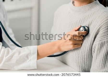 Close up of Female Doctor using stethoscope putting beat heart diagnose with patient in examination room at a hospital, check-up body, Medical and Health Care Concept. Stock fotó © 