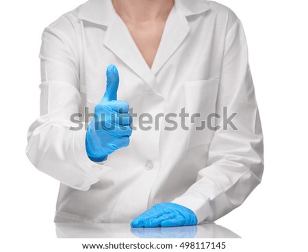 Close up of female doctor in white medical gown and blue sterilized surgical gloves showing thumbs up sign