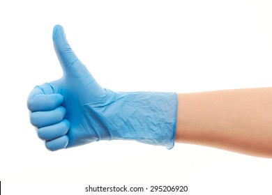 Close Up Of Female Doctor's Hand In Blue Sterilized Surgical Glove Showing Thumbs Up Sign Against White Background