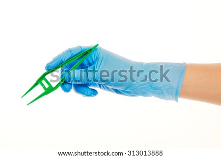 Close up of female doctor's hand in blue sterilized surgical glove with green plastic forceps against white background
