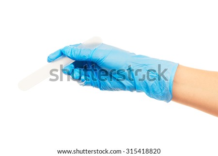 Close up of female doctor's hand in blue sterilized surgical glove with white plastic medical spatula against white background