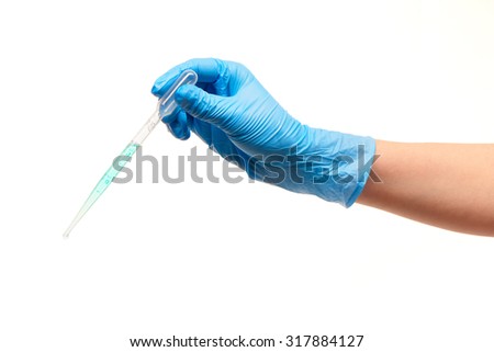 Close up of female doctor's hand in blue sterilized surgical glove with white plastic medical dropper filled with blue drug against white background