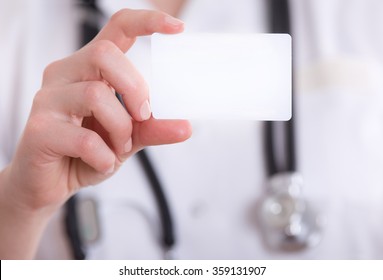 Close Up Of Female Doctor's Hand Showing Blank Business Card. Health Care Concept