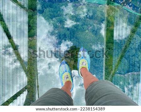 Close up of female feet walking on glass bridge over Dashbashi Canyon. Dashbashi, Georgia. High quality picture.