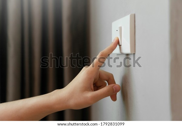Close up of\
Female finger is turn off on lighting switch at home. Power,\
Energy, Saving Electrical, Copy space.\
