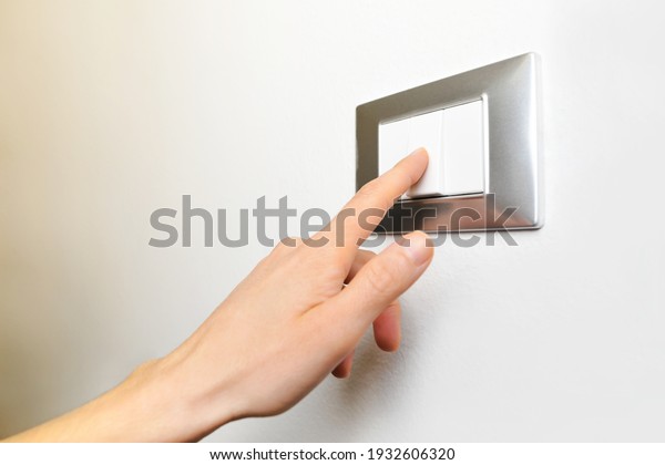 Close up of Female\
finger is turn off on lighting switch at home. Power, Energy,\
Saving Electrical, Copy\
space.
