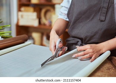 Close Up Of Female Florist Hands Cutting Color Wrapping Paper With Scissors For Freshly Made Bouquet In The Flower Shop