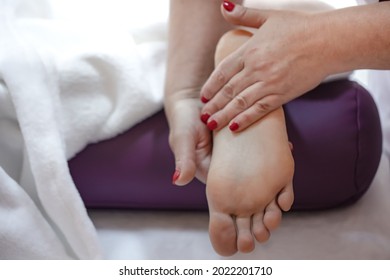 Close up of female foot in the hands of a masseur relaxing foot massage in a spa salon. - Shutterstock ID 2022201710