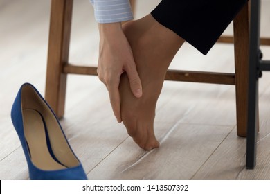 Women wearing high heels brown shoes, massaging tired legs Women wearing high heels brown shoes, massaging tired legs